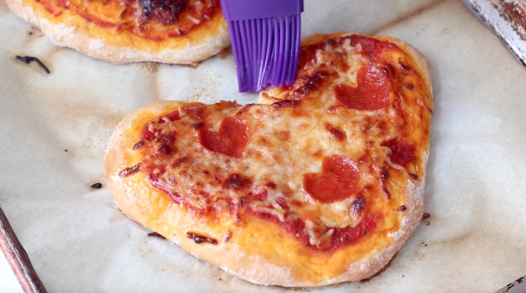 brushing pizza with garlic butter