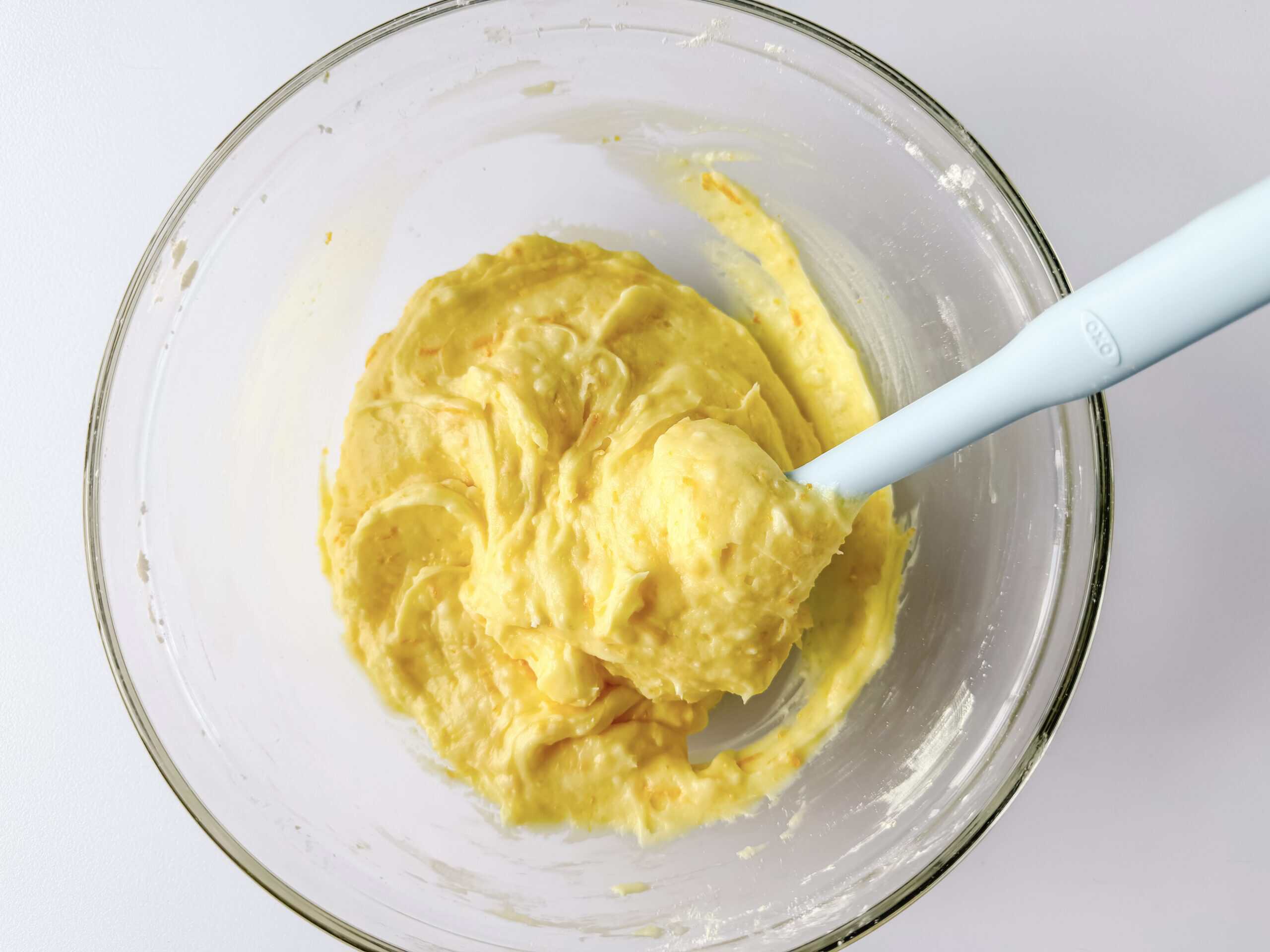 Glass bowl of orange filling for sweet rolls.