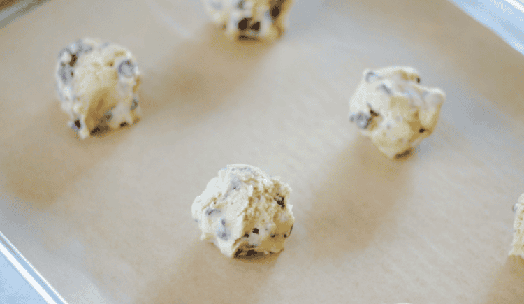 Chocolate chip cookie dough balls on baking sheet.