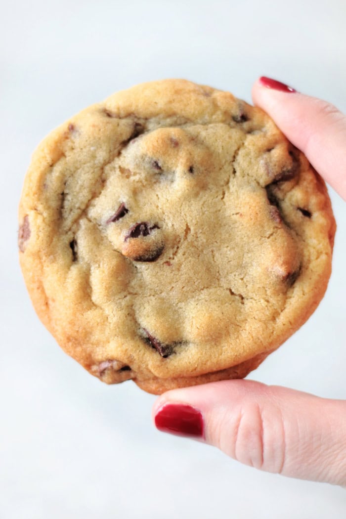 hand holding chewy toll house cookie