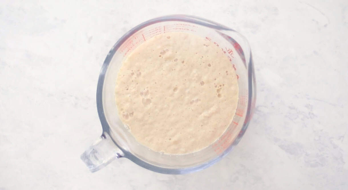 Glass measuring bowl of water and yeast.
