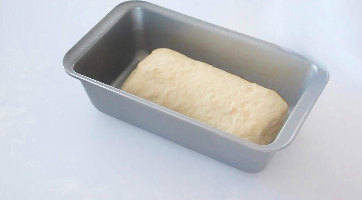 Unbaked bread in loaf pan.
