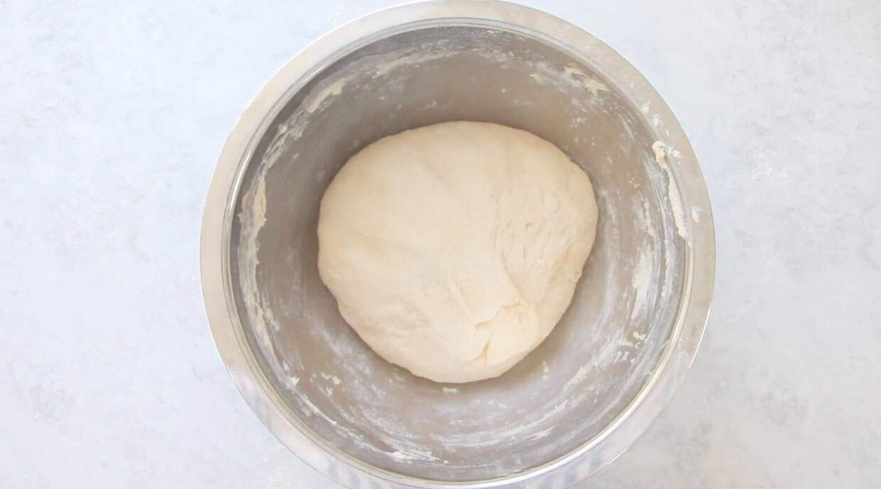 Large mixing bowl with unproofed bread dough.