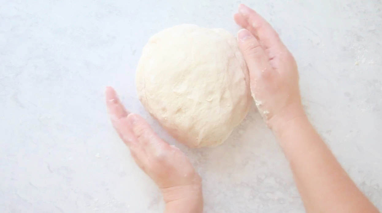 Hand kneading ball of bread dough.