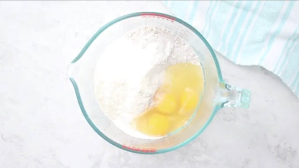 Glass mixing bowl with cake mix, eggs, oil and water.