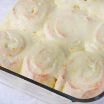 pan of orange rolls, frosted