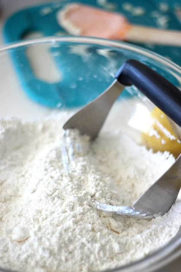 Mixing bowl with flour and pastry cutter.