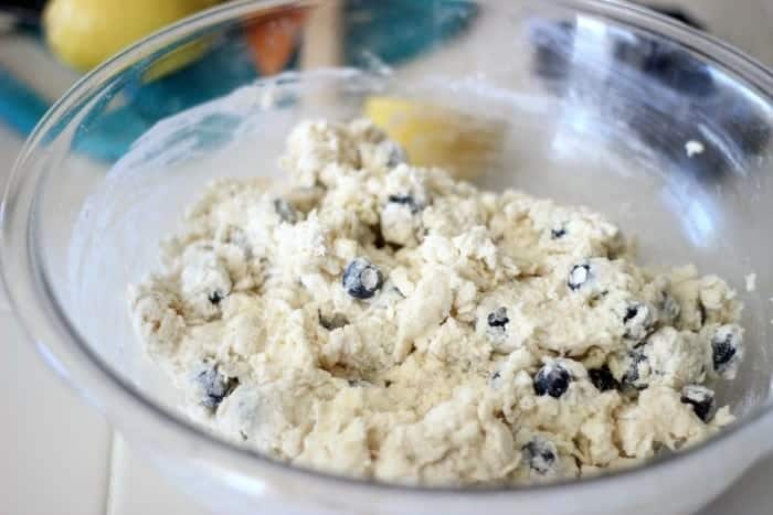 Glass mixing bowl of blueberry scone dough.