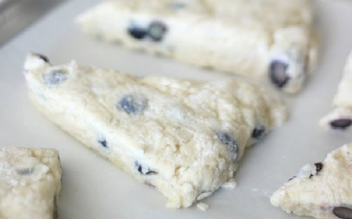 Unbaked scones on baking sheet with parchment paper.