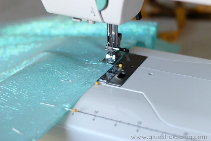 sewing machine stitching over blue sparkly fabric for elsa skirt