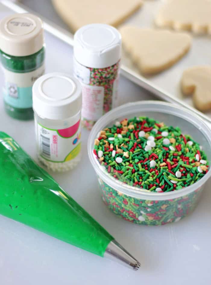 bag of green frosting and tubs of sprinkles