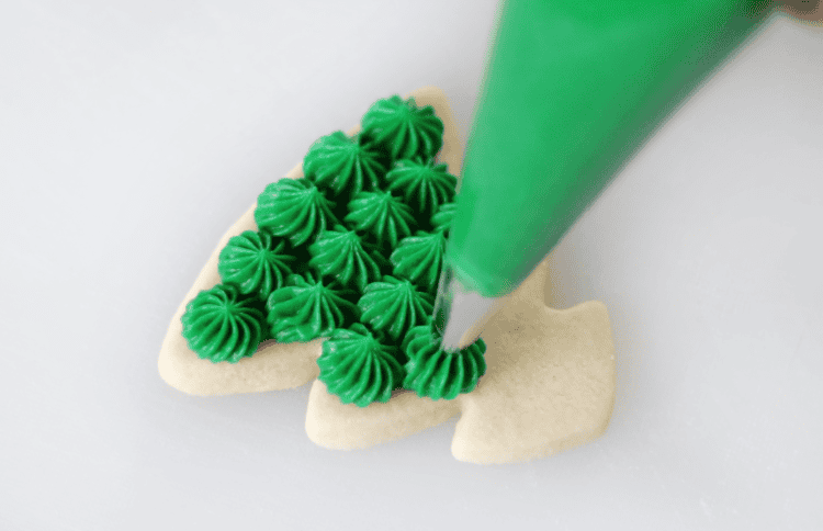 tree cookie decorated with bursts of green frosting