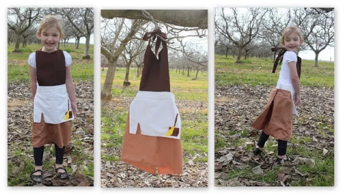 Little girl wearing Cinderella work apron.