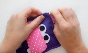 sewing hippo softie closed with a needle and thread