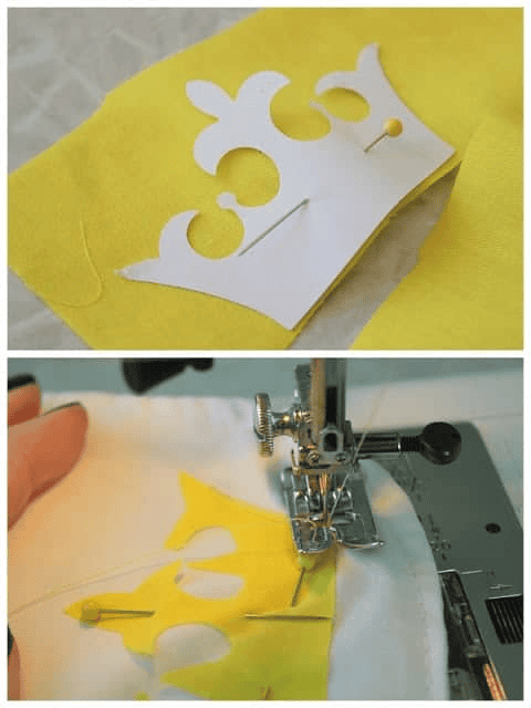 Paper crown applique pattern pinned to yellow fabric, then the yellow applique zig-zagged to the apron front.