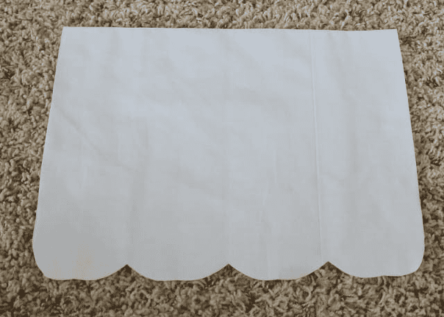 White apron front with scallops cut from bottom.