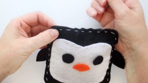 hands stitching penguin closed