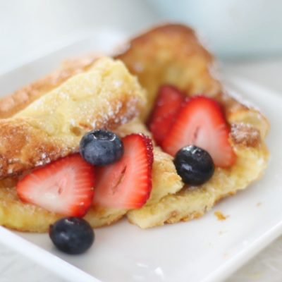 puffy pancakes on plate with strawberries and blueberries