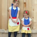 Two little girls wearing Snow White aprons.