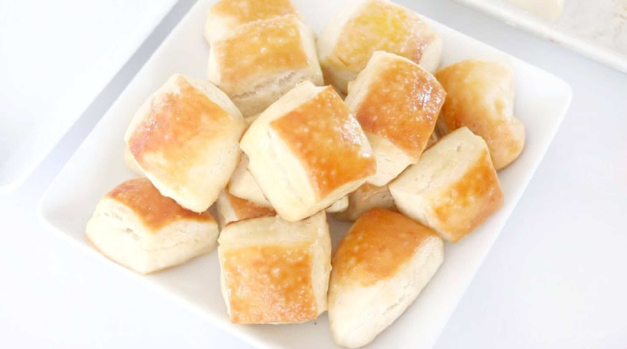 Butter and salt pretzel bites on white plate.