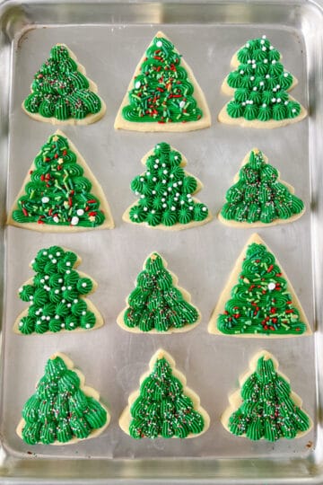 baking sheet with frosted christmas tree cookies