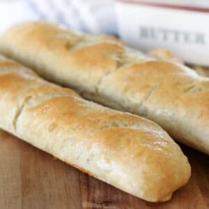 Two loaves of French bread on cutting board.
