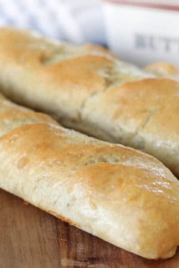 Two loaves of French bread on cutting board.