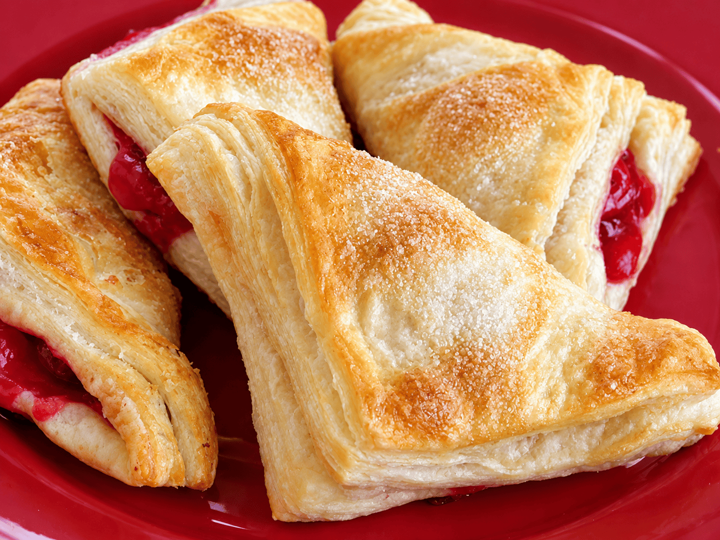 Red plate with cherry turnovers.