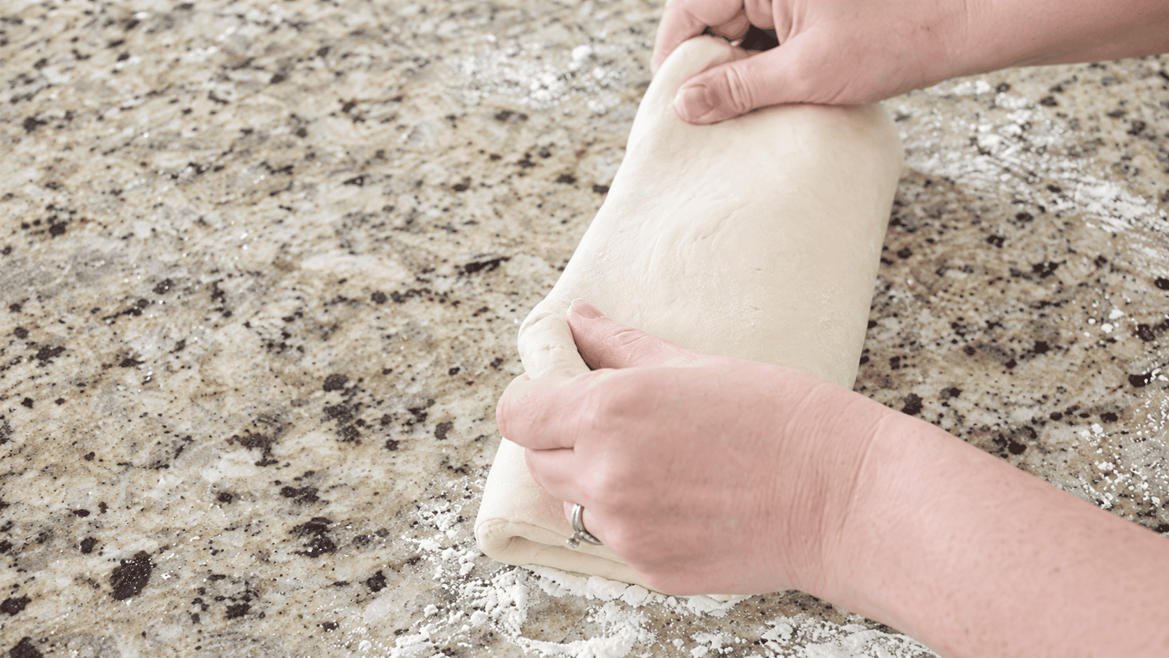 Hands folding dough into thirds.