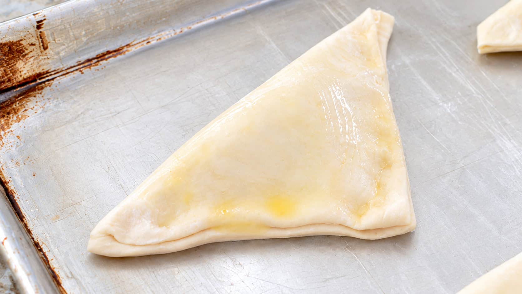 Unbaked turnovers on baking sheet.