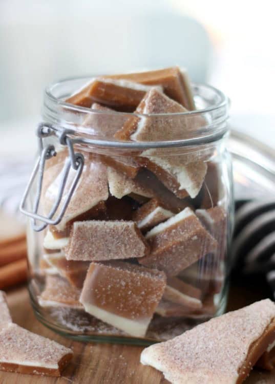 clear jar with toffee inside and toffee in front on a cutting board