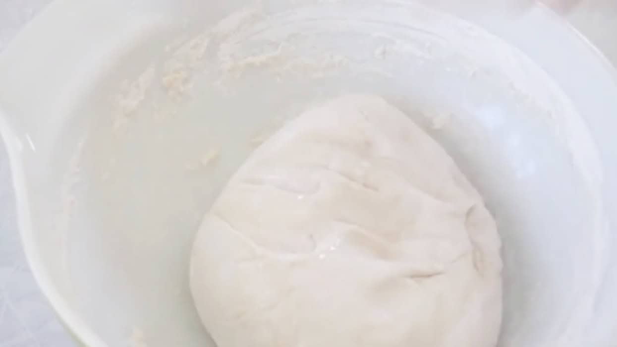 Mixing bowl with ball of bread dough.