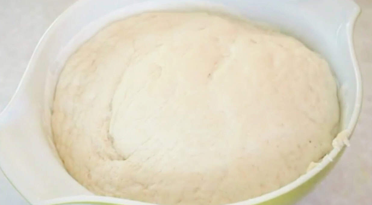 Proofed bread dough in bowl.