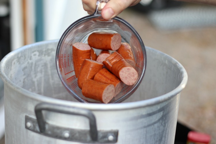 kielbasa in bowl being poured into pot