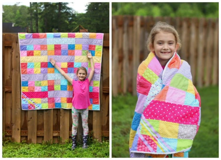 little girl standing next to finished quilt