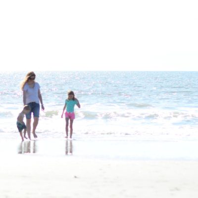 mom and kids walking on beach