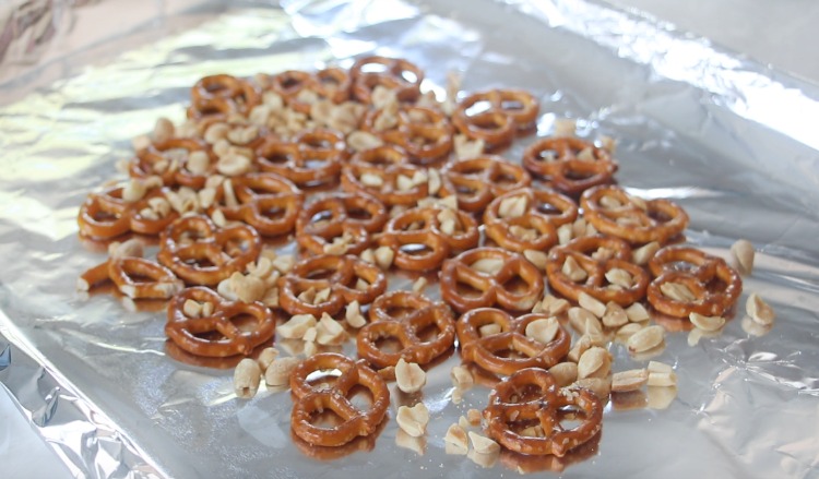 baking sheet lined with foil with pretzels and chopped peanuts