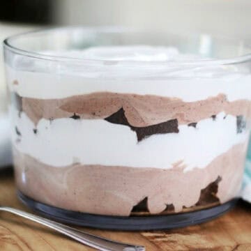 Glass trifle bowl layered with brownie, cream, and pudding.