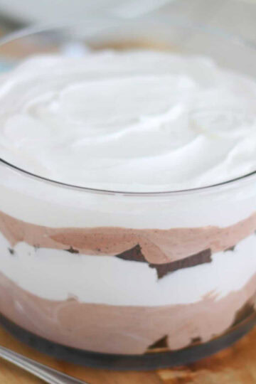 Glass trifle bowl layered with brownies, cream and pudding.