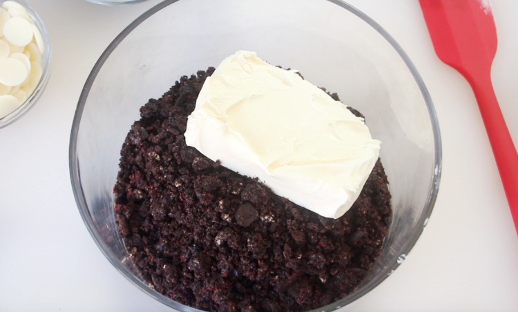 crushed Oreo cookies in bowl with brick of cream cheese