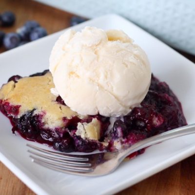 serving of cobbler with ice cream on white plate