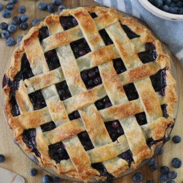 lattice top blueberry pie baked and resting on cutting board
