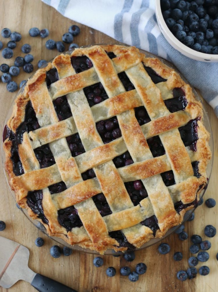 lattice top blueberry pie baked and resting on cutting board