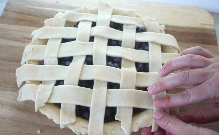 hands pinching off pie crust to seal