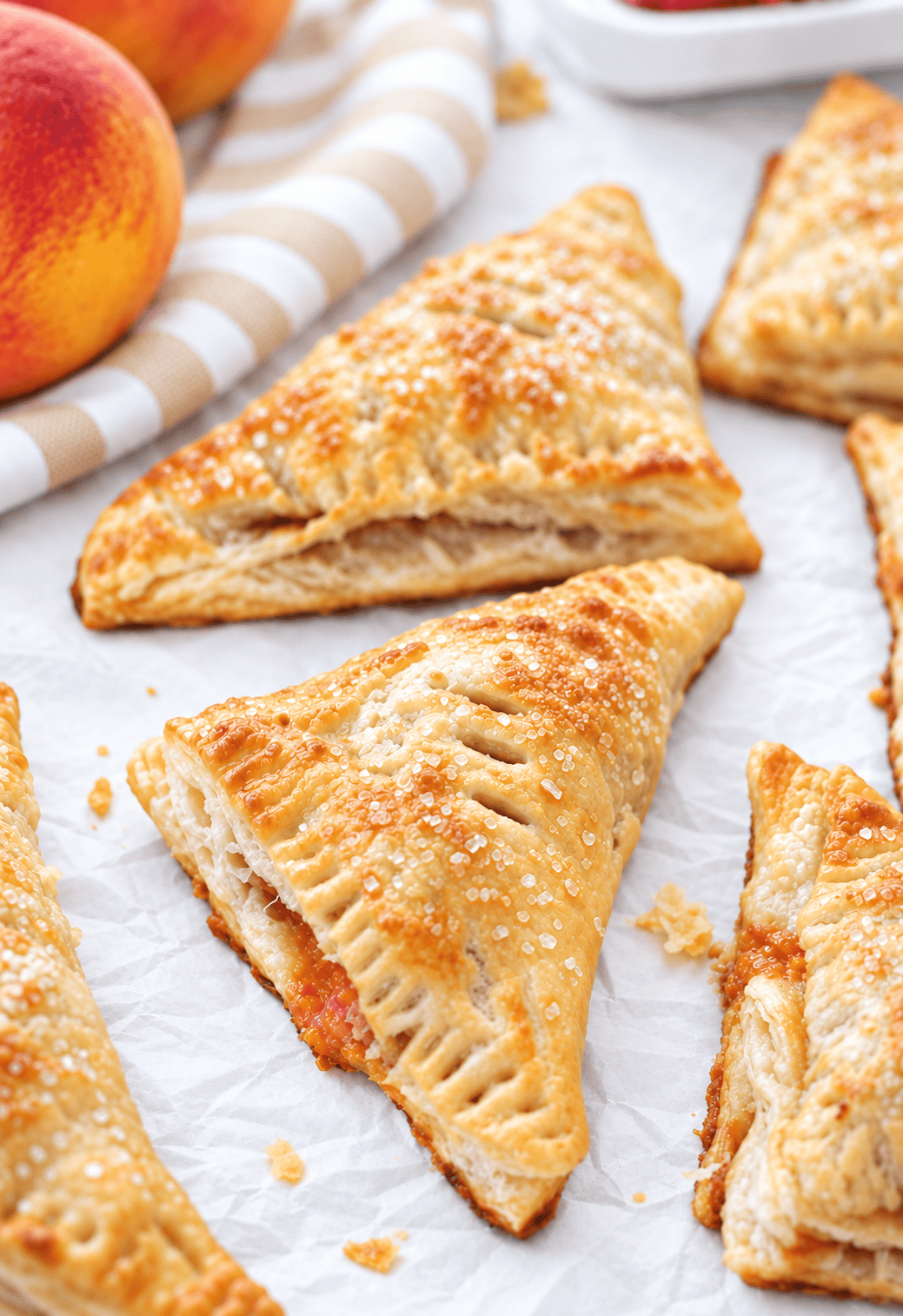 Peach turnovers on parchment paper.