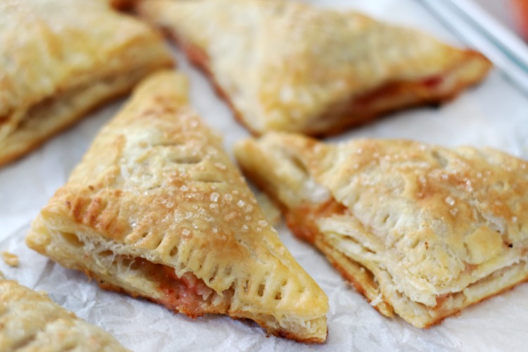 baked peach turnovers on parchment paper