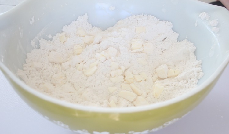 cubes of butter tossed in flour in mixing bowl