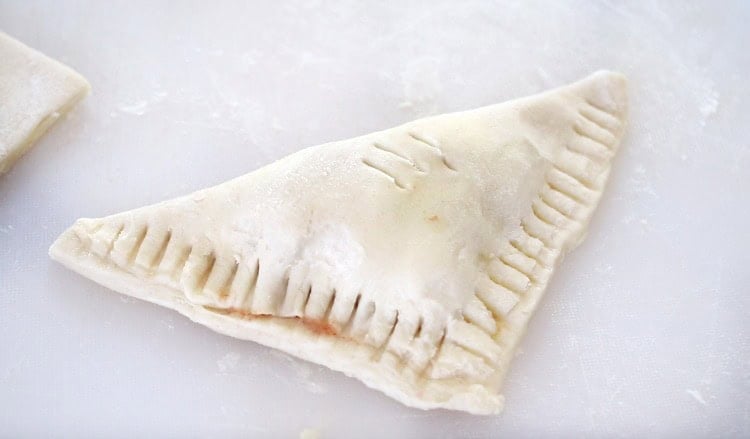 Puff pastry filled with peach filling and crimped.