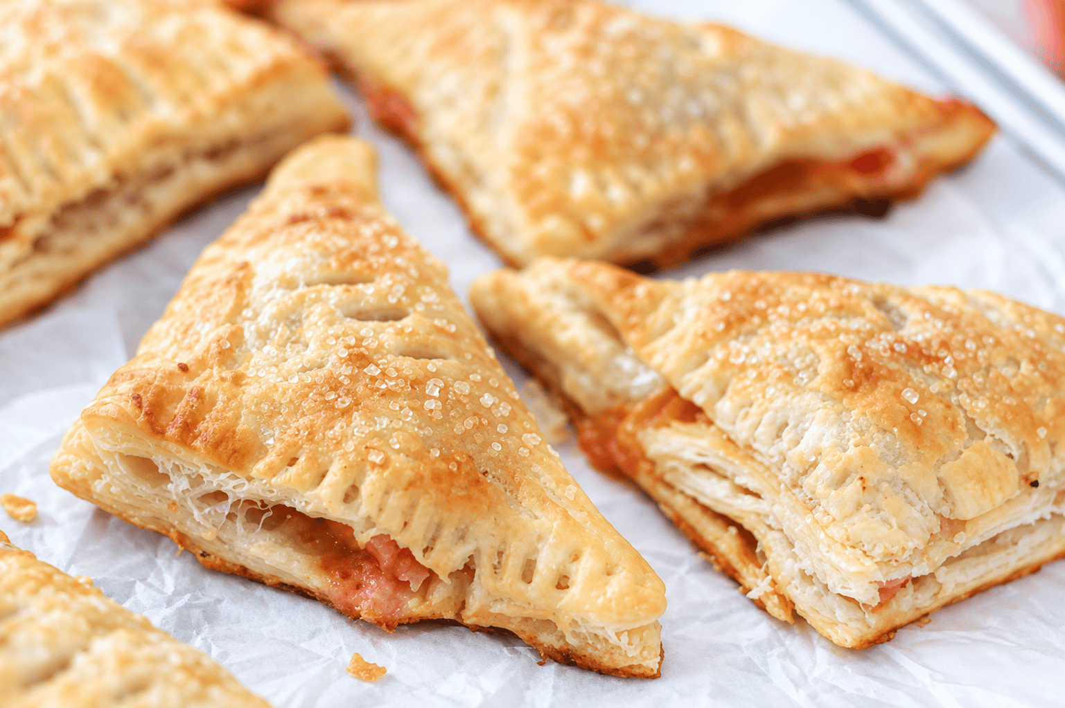 Peach turnovers on parchment paper.