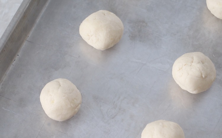 balls of sugar cookie dough on baking sheet